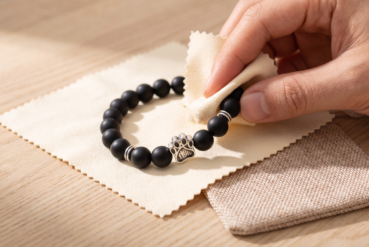 Bracelet en perles avec petite patte posé sur un tissu doux